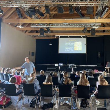 Hans Hermann Jansen (stehend) und die Kinder der Evangelischen Singschule Detmold in der Abtei Marienmünster
