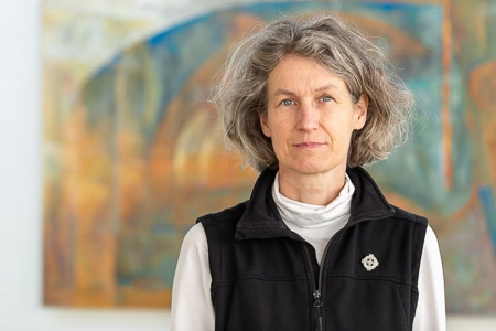 Vrouw met grijs haar en vest.